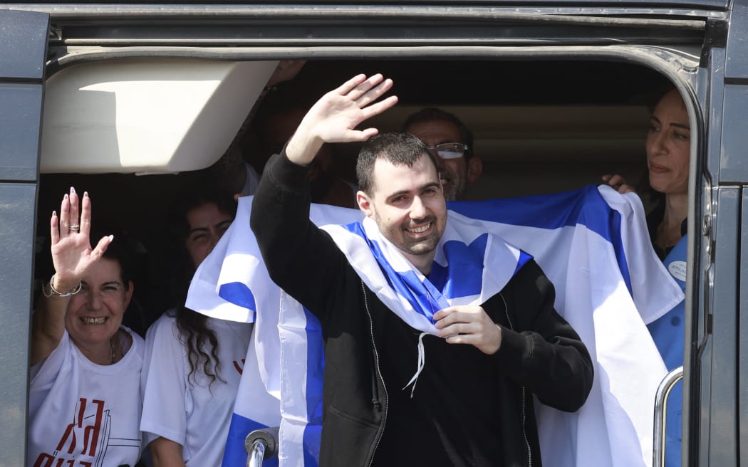 Released Israeli hostage Guy Gilboa Dalal waves to well wishers upon arriving at Beilinson Hospital in the Rabin Medical Centre in Petah Tikva in central Israel on October 13, 2025. Israel said that the last 20 living hostages released by Hamas on October 13, had arrived in the country. (Photo by Menahem Kahana / AFP)
