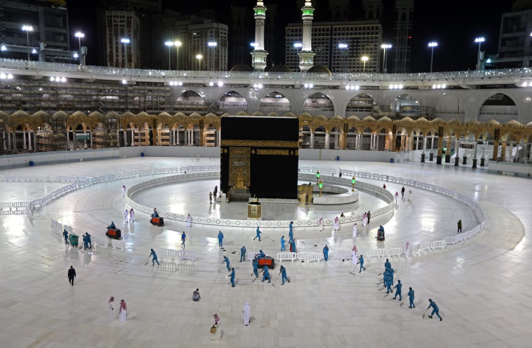 In this file photo taken on April 24, 2020, sanitation workers disinfect the area around the Kaaba in Mecca's Grand Mosque, on the first day of the Islamic holy month of Ramadan, amid unprecedented bans on family gatherings and mass prayers due to the coronavirus (COVID-19) pandemic.