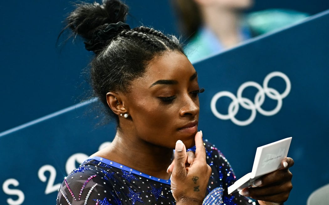 Simone Biles touches up her make up during the artistic gymnastics women's all around final.