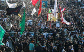 Hundreds of Iraqi Shiites Muslims chant anti-U.S. and anti-Israel slogans, during a rally the day after his assassination of Iran's supreme leader, during a symbolic funeral in the district of Sadr City, in Baghdad on March 1, 2026. Iran's supreme leader since 1989 and sworn enemy of the West, was killed in the opening salvo of a massive US and Israeli attack, sparking a new wave of retaliatory missile strikes from Tehran on March 1. (Photo by AHMAD AL-RUBAYE / AFP)