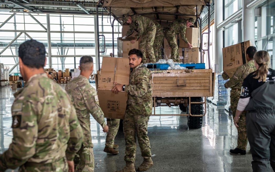 Army personnel from 16 Field Regiment unload supplies at the Central Distribution Centre in Auckland alongside volunteers from the Auckland City Council.  Essential supplies such as blankets, torches and pillows will be distributed throughout Auckland as part of Op Awhina.