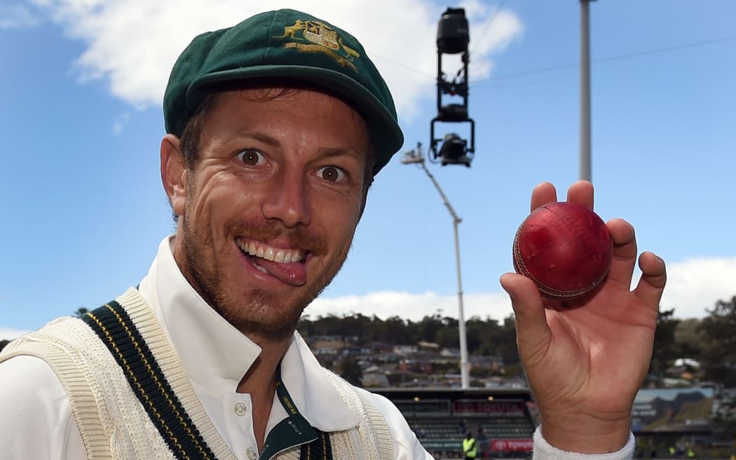 Australian paceman James Pattinson holds the ball after taking five West Indies wickets on the third day of the first cricket Test match in Hobart on December 12, 2015. AFP PHOTO / William WEST