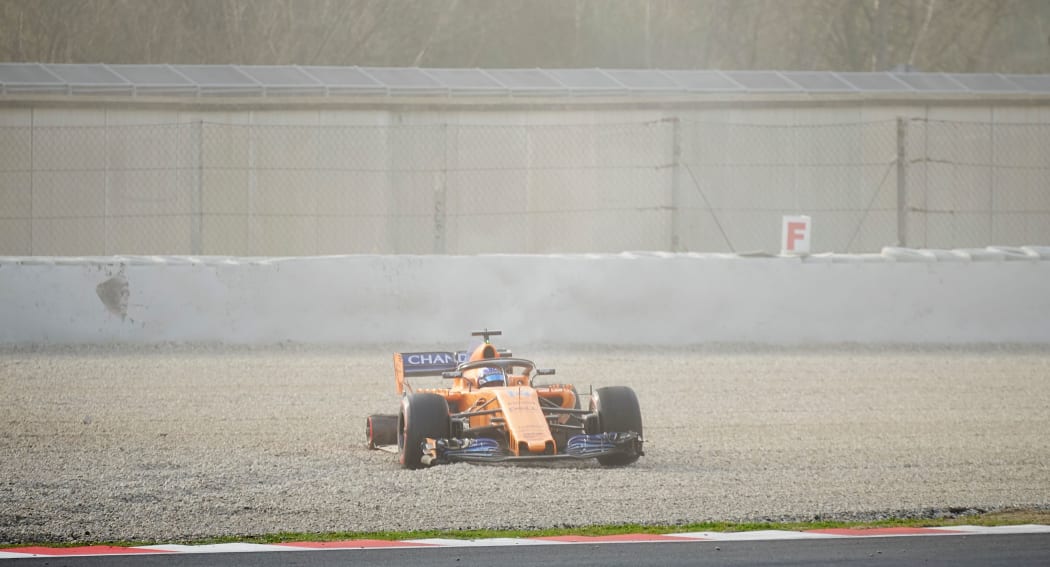 Fernando Alonso of the Mclaren F1 Team loses his wheel during the first test session