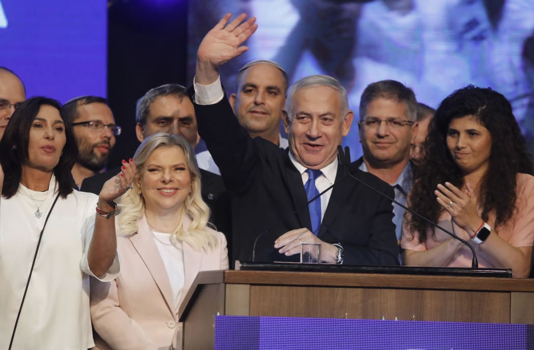 Israeli Prime Minister Benjamin Netanyahu (C) waves to supporters alongside his wife Sara Netanyahu (C-L) at his Likud party's electoral campaign headquarters early on September 18, 2019.