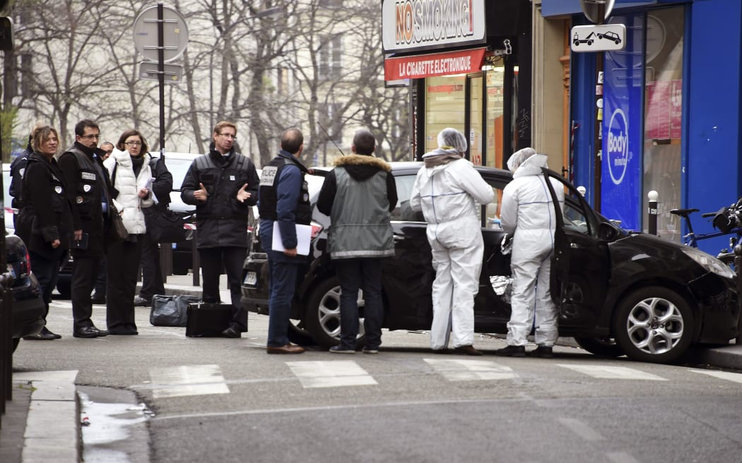 French police officers and forensic experts examine the car used by armed gunmen who stormed the Paris offices of satirical newspaper Charlie Hebdo.