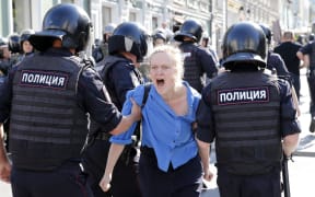 Police officers detain a protester during an unauthorised rally in downtown Moscow on July 27, 2019.