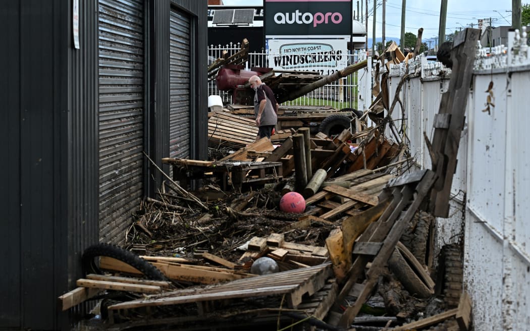 A resident visits a waterlogged motorcycle showroom on the banks of the Manning River in Taree on May 23, 2025. Record floods cut a destructive path through eastern Australia on May 23, caking houses in silt, washing out roads and separating 50,000 people from help. (Photo by Saeed KHAN / AFP)