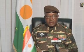 This video frame grab image obtained by AFP from ORTN - Télé Sahel on 28 July, 2023 shows General Abdourahamane Tchiani speaking on national television and reads a statement as "President of the National Council for the Safeguarding of the Fatherland", after the ousting of President-elect Mohamed Bazoum. The chief of the Presidential Guard justifies the coup by evoking "the continued deterioration of the security situation" in the country, as well as "poor economic and social governance". (Photo by ORTN - Télé Sahel / AFP)