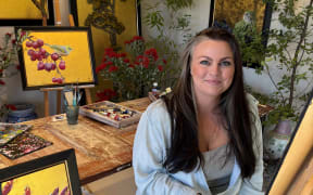 Anna Gibbs sitting in her studio.