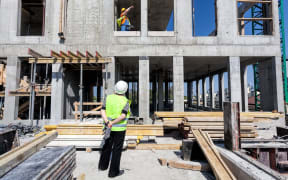 Construction site manager of a building site looking on a structure