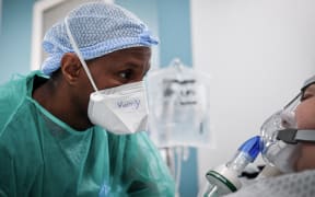 A nurse tends to a Covid-19 patient at the intensive care unit of the Delafontaine AP-HP hospital in Saint-Denis, outside Paris, on December 29, 2021.