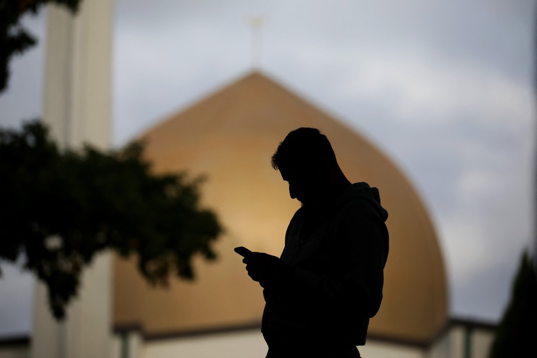 A member of the Muslim community uses his mobile phone out side the Al Noor mosque in Christchurch, New Zealand on March 15, 2020.