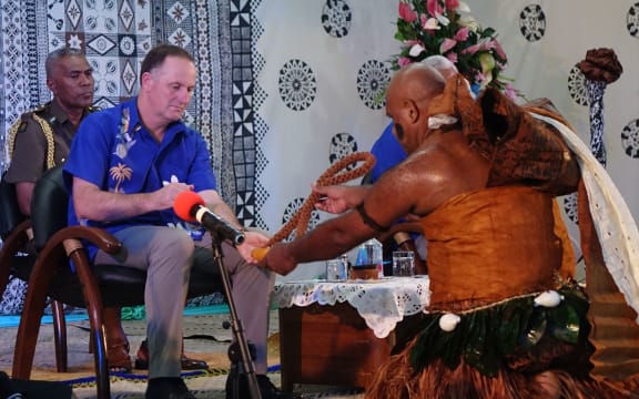 John Key receives the tabua - a whale tooth - during the welcoming ceremony.
