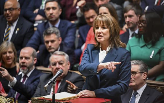 This handout photograph taken and released by the UK Parliament's House of Commons on November 26, 2025 shows Britain's Chancellor of the Exchequer Rachel Reeves (R) speaking in the House of Commons in London as the government delivered its annual budget. Britain's Labour government unveiled a tax-raising budget on November 26 costing billions of pounds to curb debt and fund public services, as the country faces lower economic growth in the coming years. (Photo by Handout / House of Commons / AFP) / RESTRICTED TO EDITORIAL USE - MANDATORY CREDIT " AFP PHOTO / HOUSE OF COMMONS " - NO USE FOR ENTERTAINMENT, SATIRICAL, MARKETING OR ADVERTISING CAMPAIGNS - EDITORS NOTE THE IMAGE MAY HAVE BEEN DIGITALLY ALTERED AT SOURCE TO OBSCURE VISIBLE DOCUMENTS - BEST QUALITY AVAILABLE /