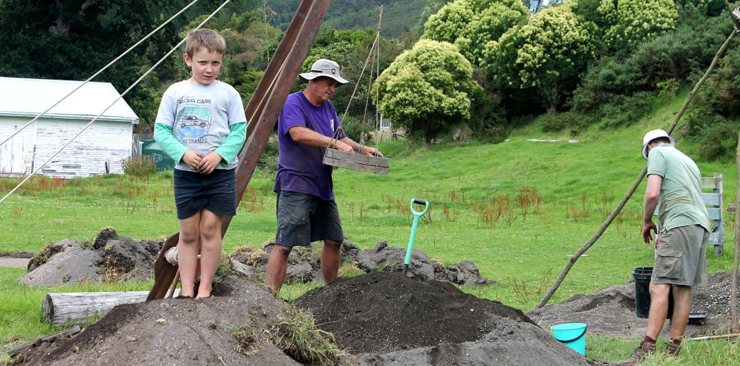 Sieving all the dug-up earth. Local kid Ollie, poses.