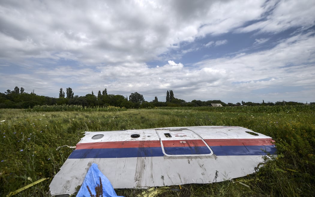 (FILES) A wreckage of the Malaysia Airlines flight MH17 is seen in a field near the village of Grabove, in the region of Donetsk on July 20, 2014. The families of the victims of the downing of flight MH17 in war-torn eastern Ukraine are this week commemorating ten years since the tragedy, with dwindling hopes of seeing those responsible behind bars. (Photo by Bulent KILIC / AFP)
