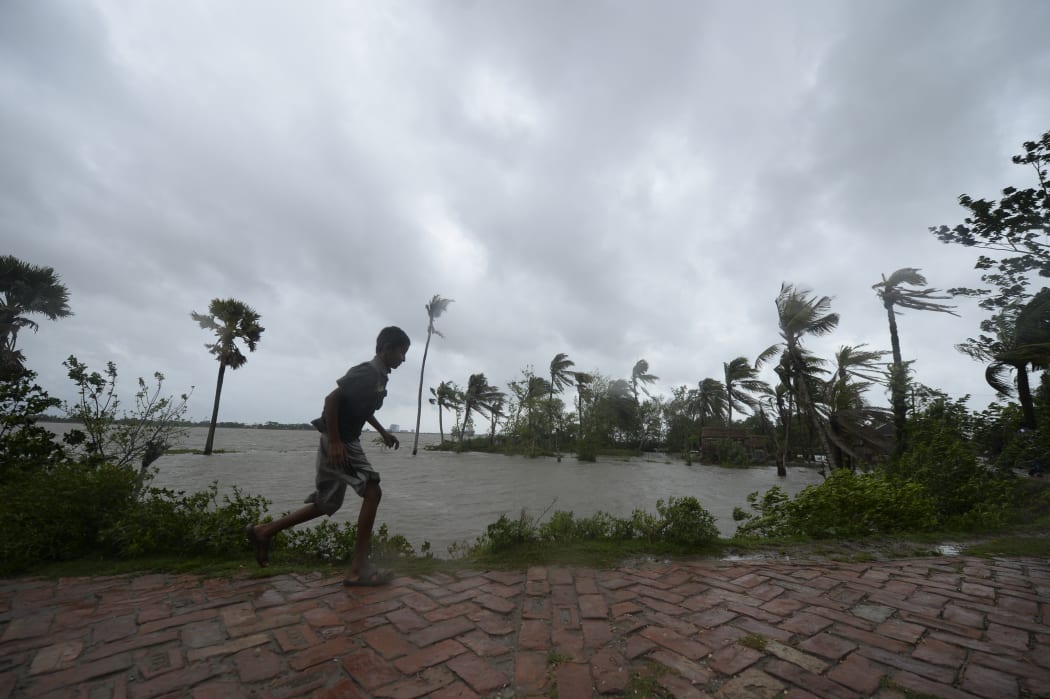 A boy runs along an embankment ahead of the expected landfall of cyclone Amphan, in Dacope, Bangladesh, on 20 May 2020.