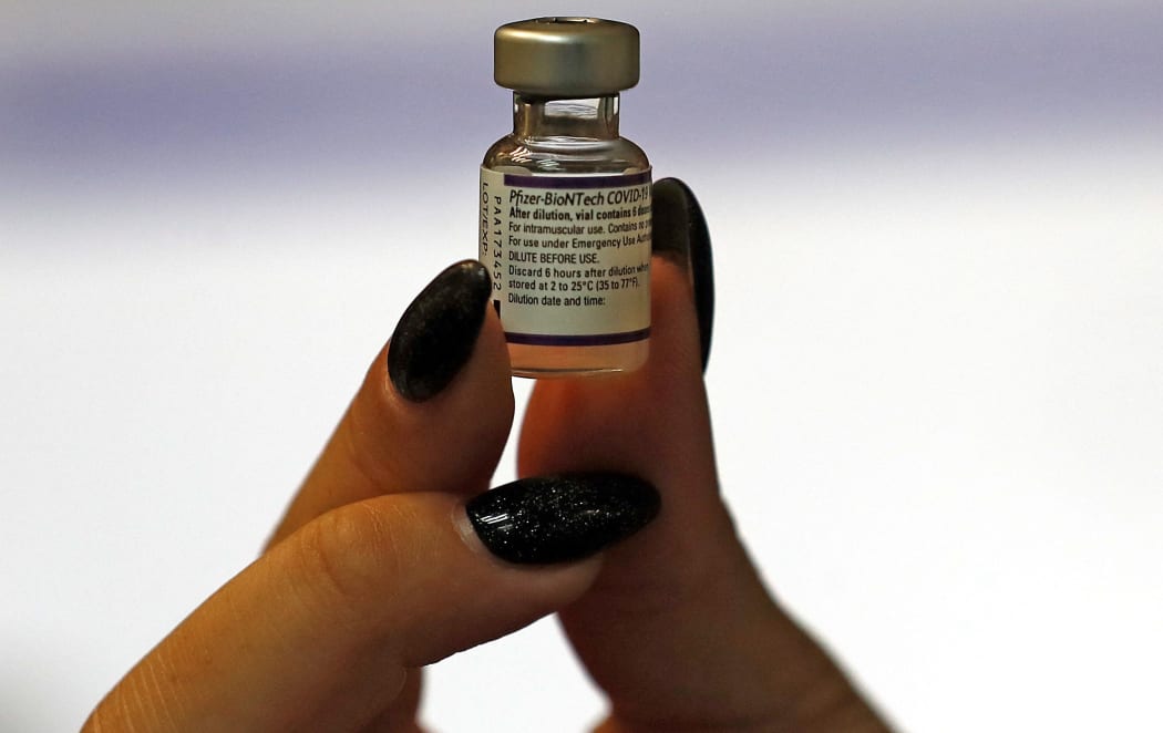 An Israeli health worker displays a vial of the Pfizer-BioNtech COVID-19 vaccine, at the Maccabi Health Service in Jerusalem on August 20, 2021 as Israel launches its campaign to give booster shots to people aged over 40,in a bid to stem spiking infections driven by the Delta variant.