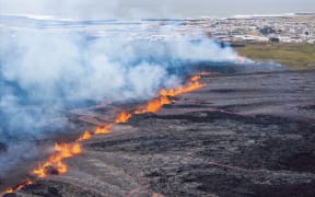 Molten lava is seen coming out of a fissure on the outskirts of the fishing village Grindavik in southwest Iceland, on April 1, 2025. The Icelandic Meteorological Office (IMO) said "an eruption has started on the Sundhnuksgigar Crater Row" north of the fishing village Grindavik that was evacuated Tuesday after lava began spewing from a volcanic eruption, the eighth to hit the region since the end of 2023. (Photo by Ael Kermarec / AFP)