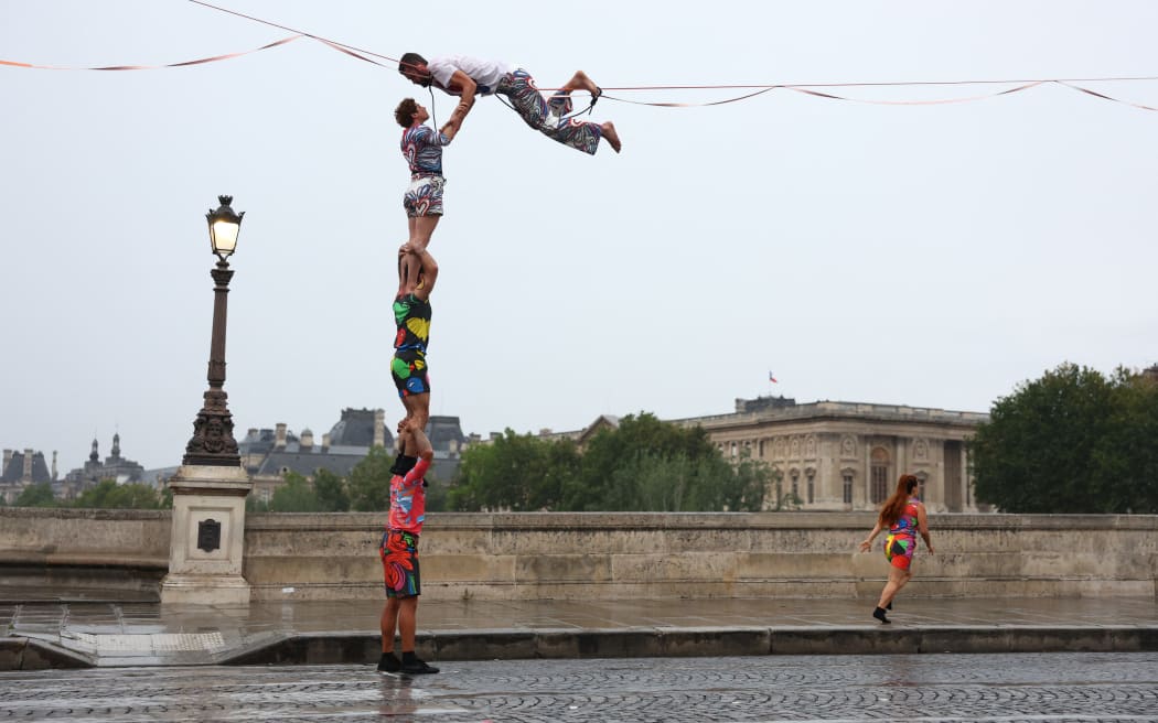PARIS, FRANCE - JULY 26: Tightrope walker Nathan Paulin performs on a high rope during the athletes’ parade on the River Seine near the Supreme Court during the opening ceremony of the Olympic Games Paris 2024 on July 26, 2024 in Paris, France. (Photo by Maddie Meyer / POOL / AFP)