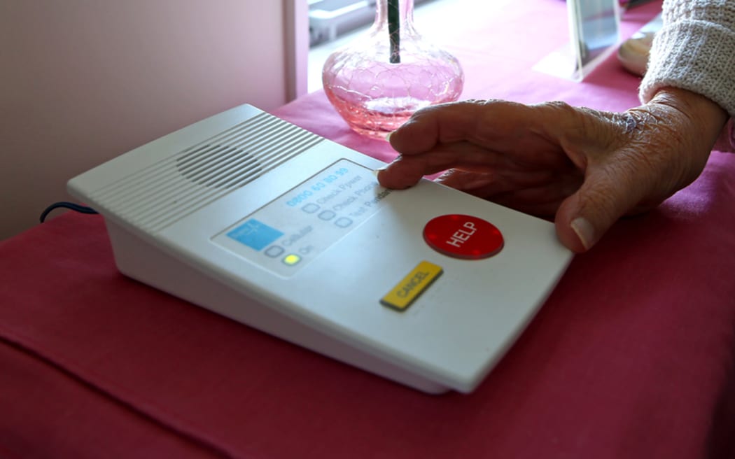 An elderly woman in her home with her medical alert device.
