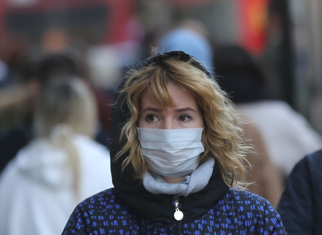 A woman in London wears a mask as a precaution against coronavirus.