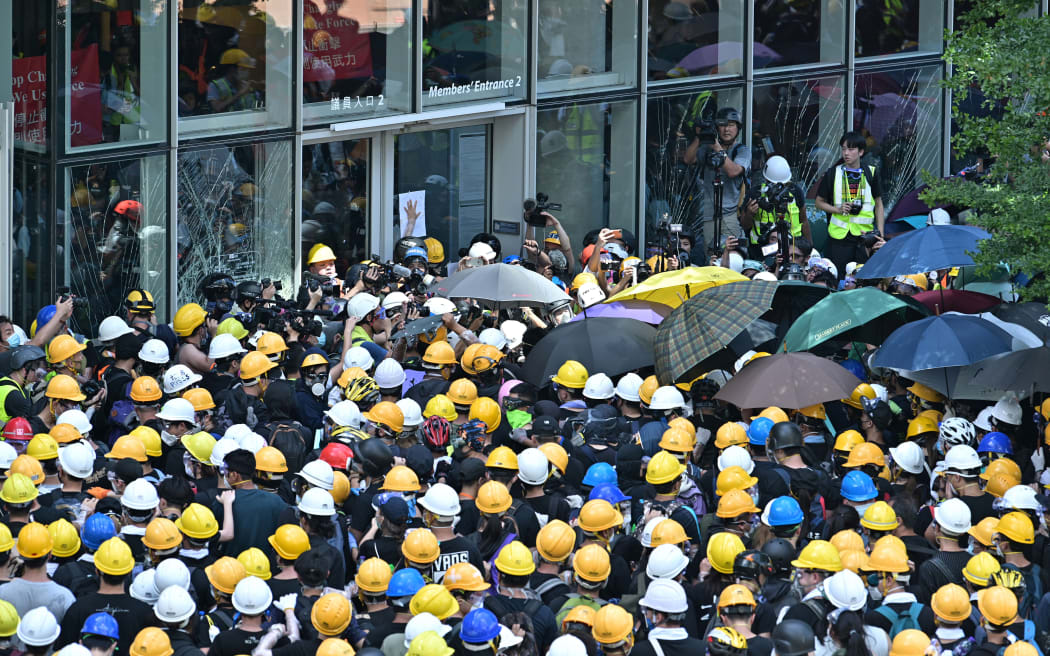 Protesters and journalists gather outside the government headquarters.