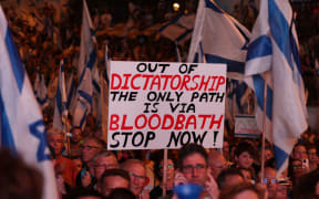 Demonstrators raise placards as they march in Jerusalem on July 22, 2023, during a multi-day march that started in Tel Aviv to protest the government's judicial overhaul bill ahead of a vote in the parliament. Israel has been rocked by a months-long wave of protests after the government unveiled in January plans to overhaul the judicial system that opponents say threaten the country's democracy. (Photo by HAZEM BADER / AFP)