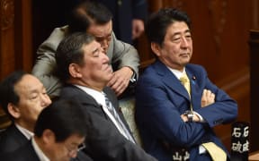 Japan's Prime Minister Shinzo Abe (right) and members of his cabinet attend a parliamentary session about the controversial security bills.
