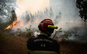 Smoke rises from a forest fire near Louchats, some 35km from Landiras in Gironde, southwestern France on 18 July 2022.