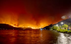 Residents watch the McDougall Creek wildfire in West Kelowna, British Columbia, Canada, on August 17, 2023, from Kelowna. Evacuation orders were put in place for areas near Kelowna, as the fire threatened the city of around 150,000. Canada is experiencing a record-setting wildfire season, with official estimates of over 13.7 million hectares (33.9 million acres) already scorched. Four people have died so far. (Photo by Darren HULL / AFP)