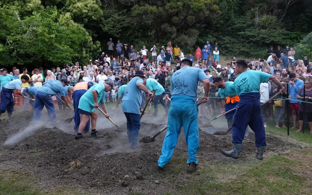 Anticipation builds in the 700-strong crowd as the hāngī is unearthed.
