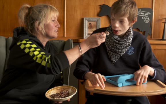 Pip Cook feeds her severely disabled foster son Ryan.