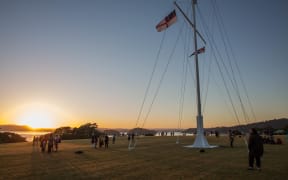 People watch on as the sun rises at the Upper Marae on Waitangi Day. 6 February 2017.