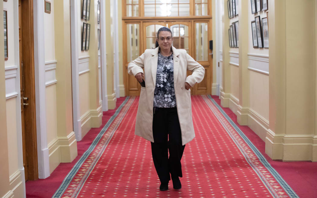 ACT Party MP Karen Chhour walks down a quiet corridor at Parliament at night.