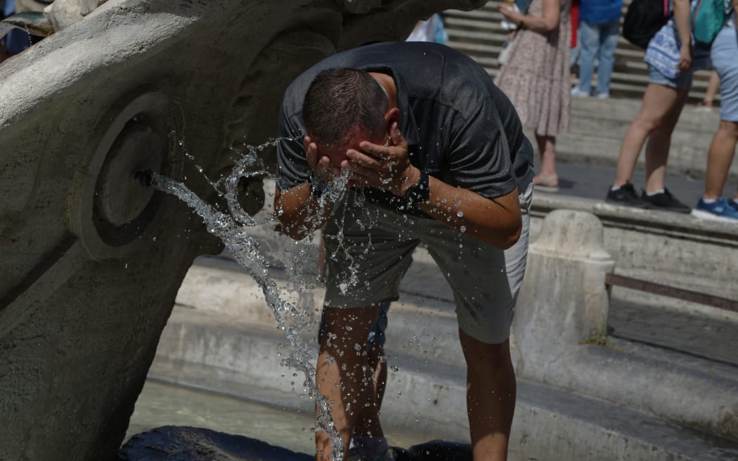 A man cools off during a heatwave with temperatures reaching 40C, at Piazza di Spagna, on 16 July 2023 in Rome, Italy.