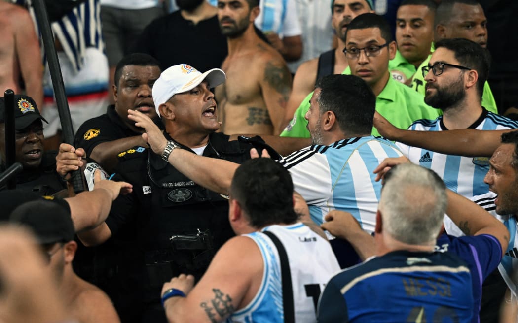 Fans of Argentina clash with Brazilian police before the start of the 2026 FIFA World Cup South American qualification football match between Brazil and Argentina at Maracana Stadium in Rio de Janeiro, Brazil, on November 21, 2023. (Photo by CARL DE SOUZA / AFP)