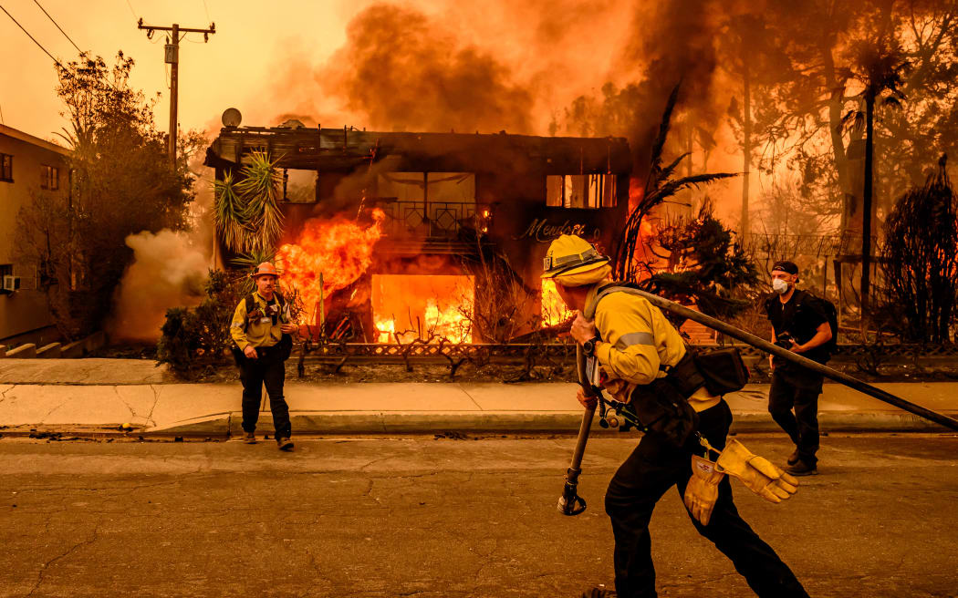Firefighters work the scene as an apartment building burns during the Eaton fire in the Altadena area of Los Angeles county, California on January 8, 2025. - At least five people are now known to have died in wildfires raging around Los Angeles, with more deaths feared, law enforcement said January 8, as terrifying blazes leveled whole streets, torching cars and houses in minutes.
More than 1,000 buildings have burned in multiple wildfires that have erupted around America's second biggest city, forcing tens of thousands of people from their homes. (Photo by JOSH EDELSON / AFP)