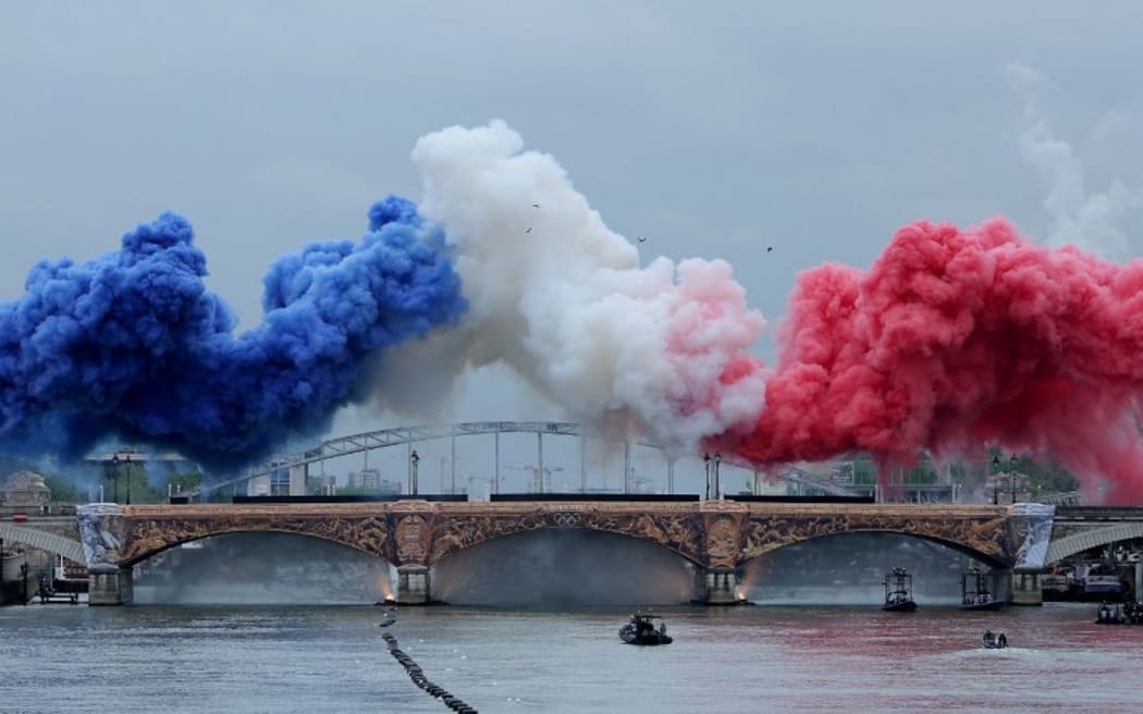 Paris 2024 Olympics - Opening Ceremony - Paris, France - July 26, 2024. Smoke clouds in the tricolours of the France flag are seen at Pont d'Austerlitz during the opening ceremony. (Photo by Ann Wang / POOL / AFP)