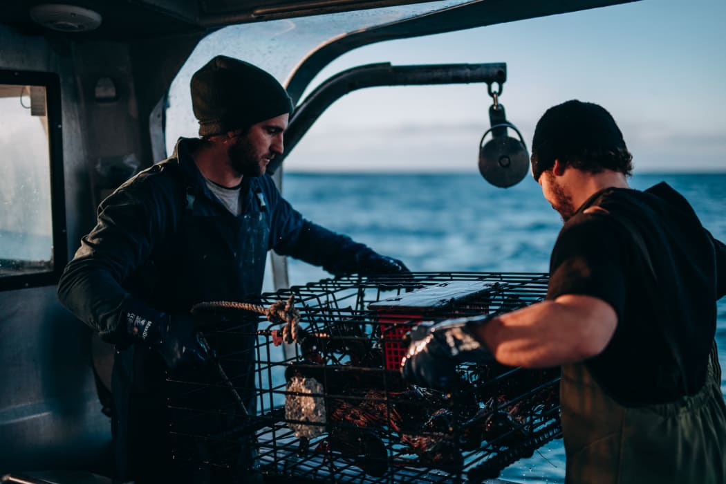 Two people working on a Tora Collective boat.