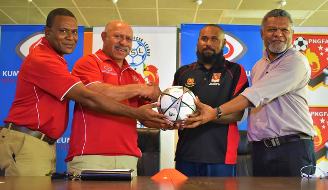 PNGFA President John Kapi Natto (2L) and   Tonga Esira (2R) at the launch of the National Soccer League's New Guinea Islands Conference.