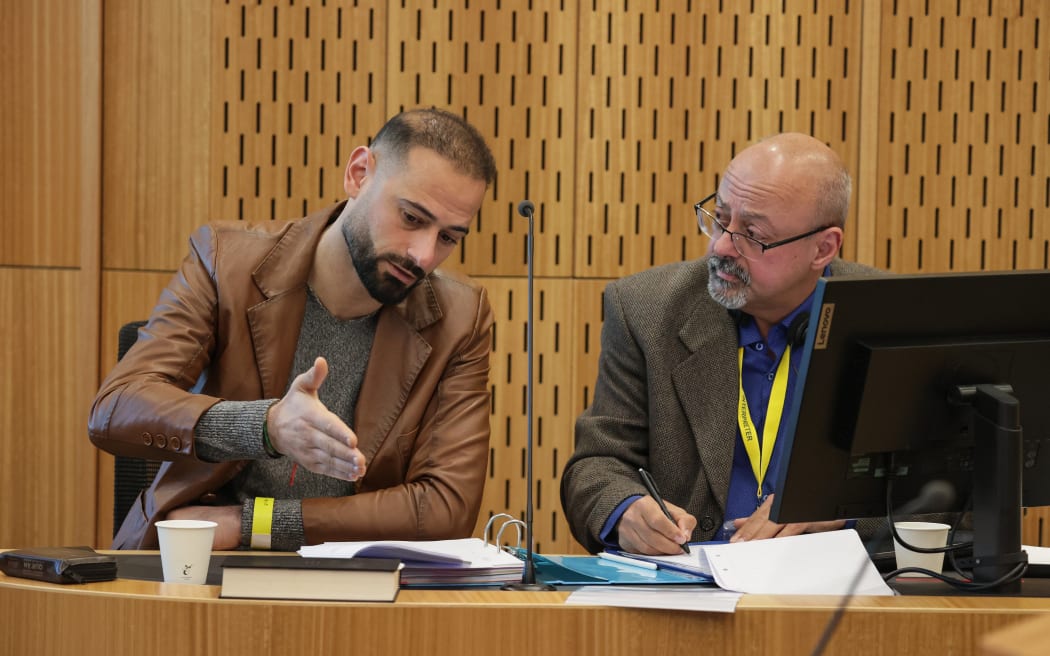 Al Noor mosque survivor Khaled Alnobani (left) with his interpreter during the Mosque Inquest held at the Christchurch Justice Precinct.