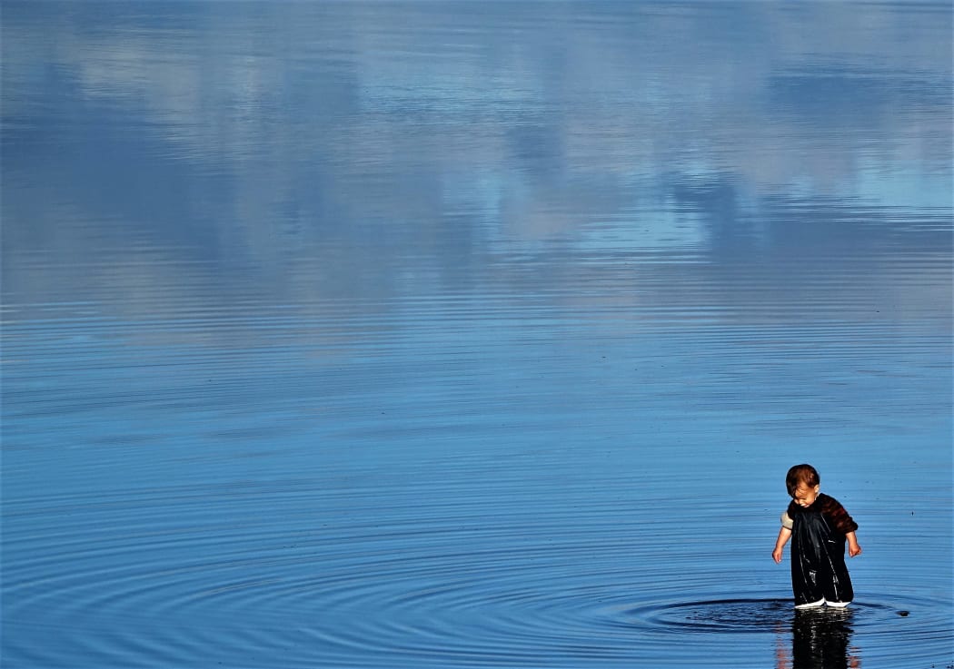 Child playing in rising tide at Motueka estuary
