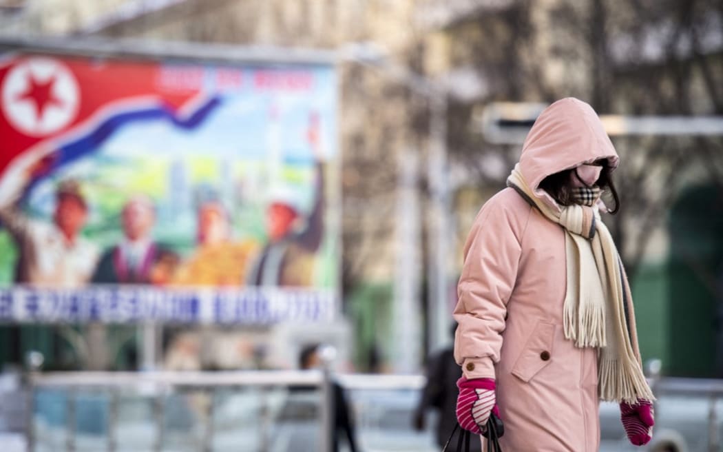 A woman walks in a street in central Pyongyang in December 2022.
