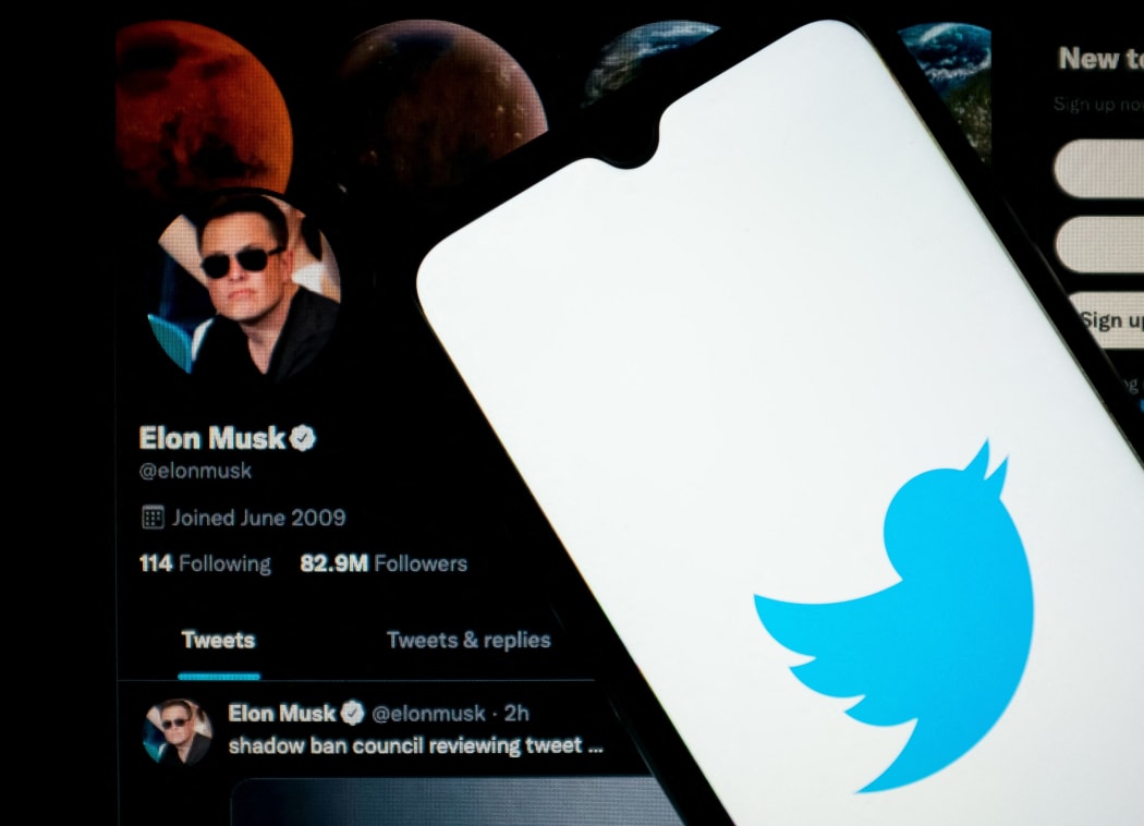 In this photo illustration Twitter logo seen displayed on a smartphone screen with Elon Musk Twitter in the background in Chania, Crete Island, Greece on April 23, 2022. )
