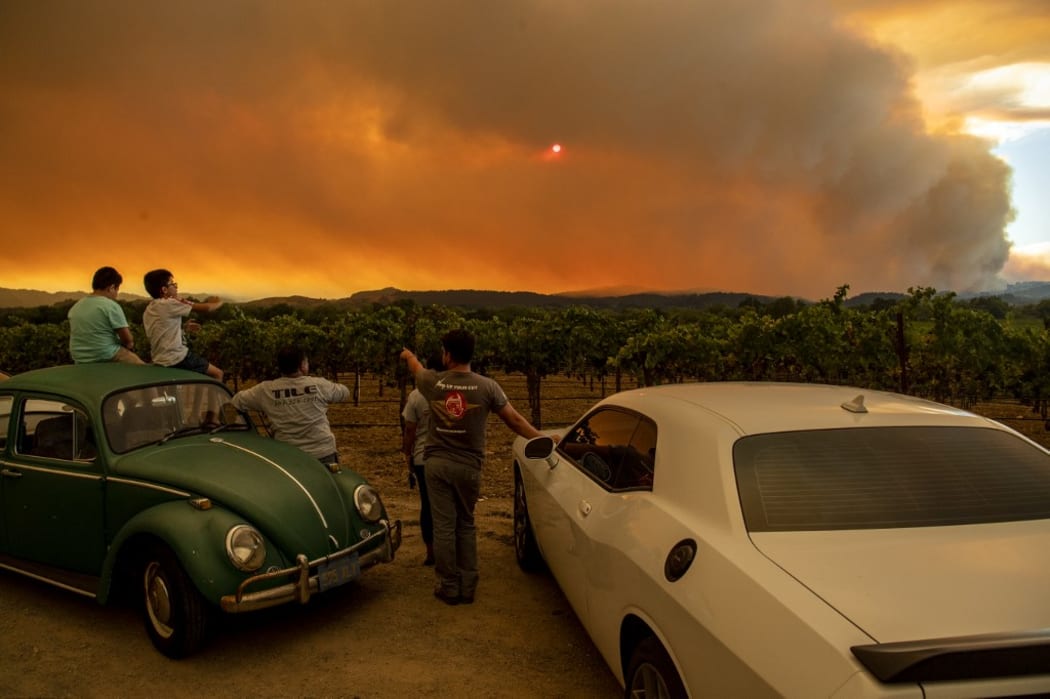 People watch the Walbridge fire, part of the larger LNU Lightning Complex fire, from a vineyard in Healdsburg, California on August 20, 2020.