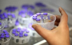 A nurse takes vials of Comirnaty vaccine by Pfizer-BioNTech against Covid-19 out of a fridge at the Baleone vaccine centre in Ajaccio on the French Mediterranean island of Corsica, on May 13, 2021.