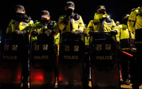 Police stand guard near the South Korean Presidential Office and the Defence Ministry in Seoul early on December 4, 2024, after South Korean President Yoon Suk Yeol declared martial law. - South Korea's President Yoon Suk Yeol on December 3 declared martial law, accusing the opposition of being "anti-state forces" and saying he was acting to protect the country from "threats" posed by the North. (Photo by ANTHONY WALLACE / AFP)