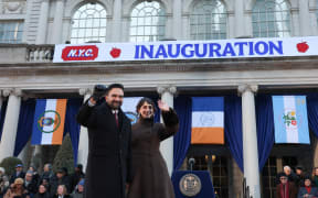 New York Mayor Zohran Mamdani and his wife Rama Duwaji wave during his public inauguration ceremony followed by a block party at City Hall in New York on January 1, 2026. Mamdani, the young upstart of the US left, was sworn in Thursday to take over as New York mayor for a term sure to see him cross swords with President Donald Trump. After the clocks struck midnight, bringing in 2026, Mamdani took his oath of office at an abandoned subway stop to begin managing the United States' largest city. He is New York's first Muslim mayor. (Photo by TIMOTHY A. CLARY / AFP)