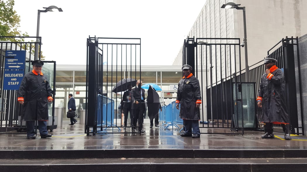Three Officers stand guard outside the barred gates of the UN in New York